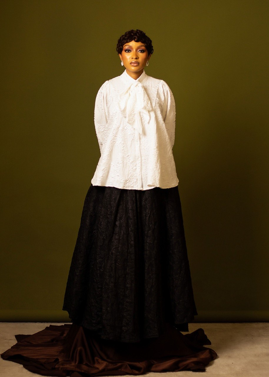 Favour Aruwei wearing a white bow blouse and long black skirt
